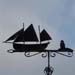 Segelschiff mit zwei Masten und Leuchtturm auf Pfeil