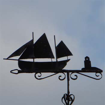 Segelschiff mit zwei Masten und Leuchtturm auf Pfeil